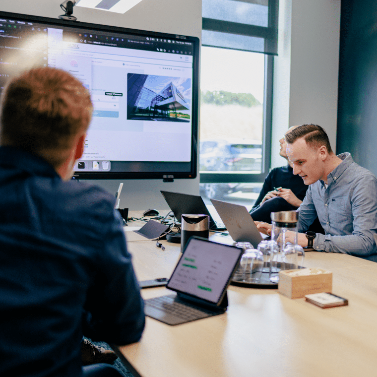 blog - Jeroen en Martijn zijn bij Altec op bezoek en zitten samen met Rens aan tafel en kijken naar een scherm