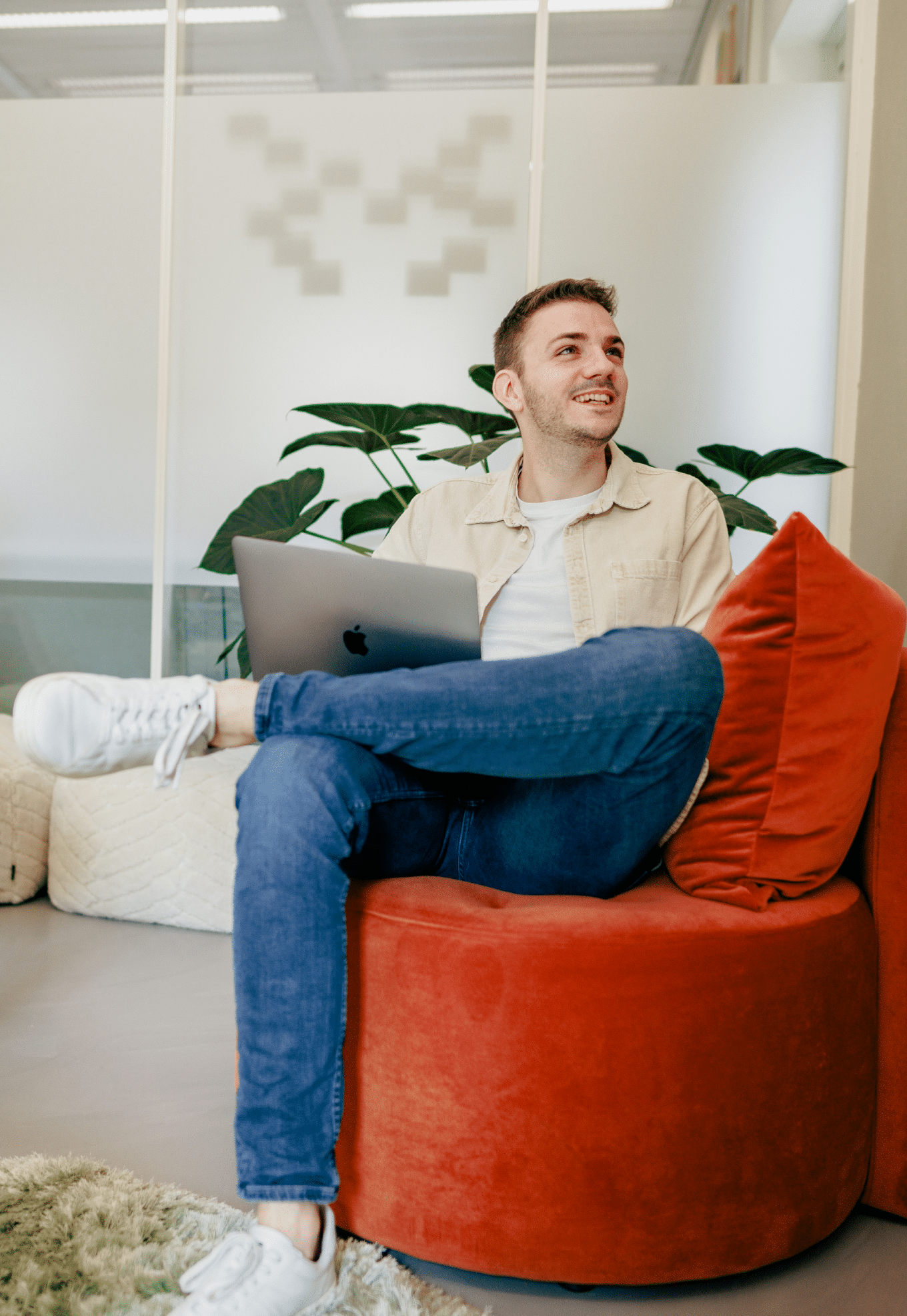 Jordy kijkt enthousiast weg van de camera met een laptop op zijn schoot bij Elephant