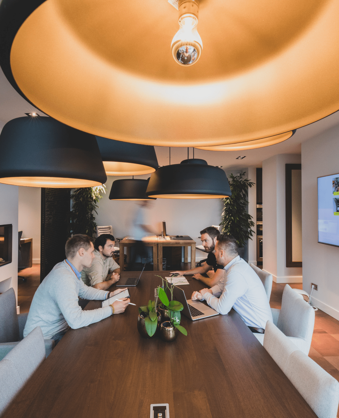 Sander, Jeroen, John en Fabian hebben een overleg aan tafel over Garagepark