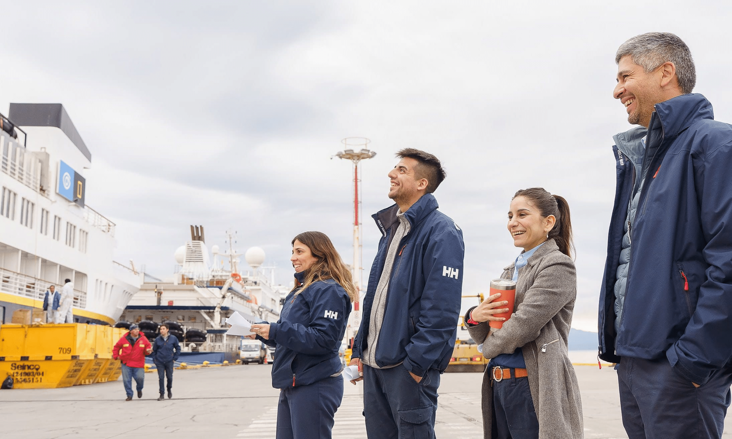 Collega's van Ushuaia staan in gesprek naar een boot te kijken