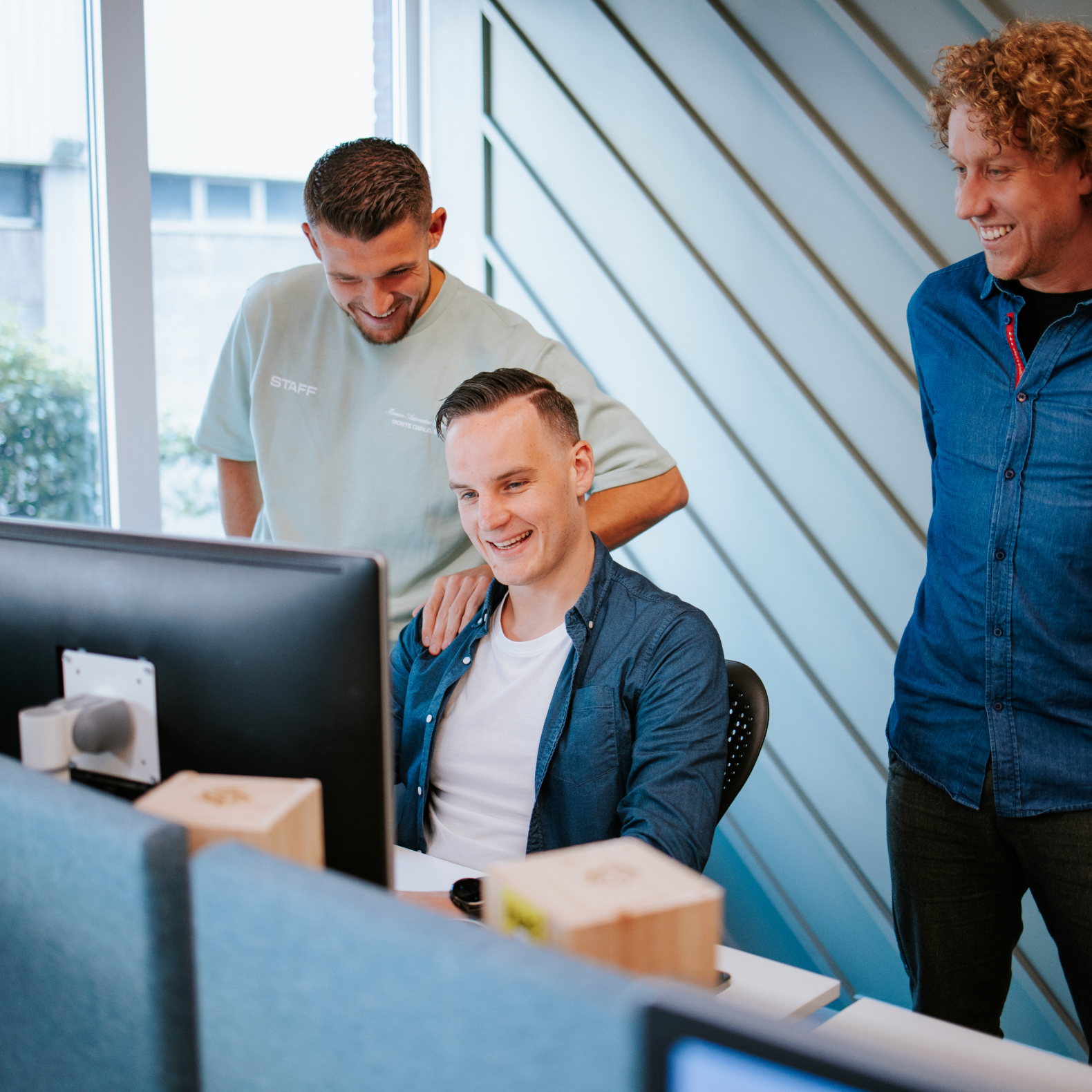 John, Bart en Martijn zitten in overleg achter hun laptop