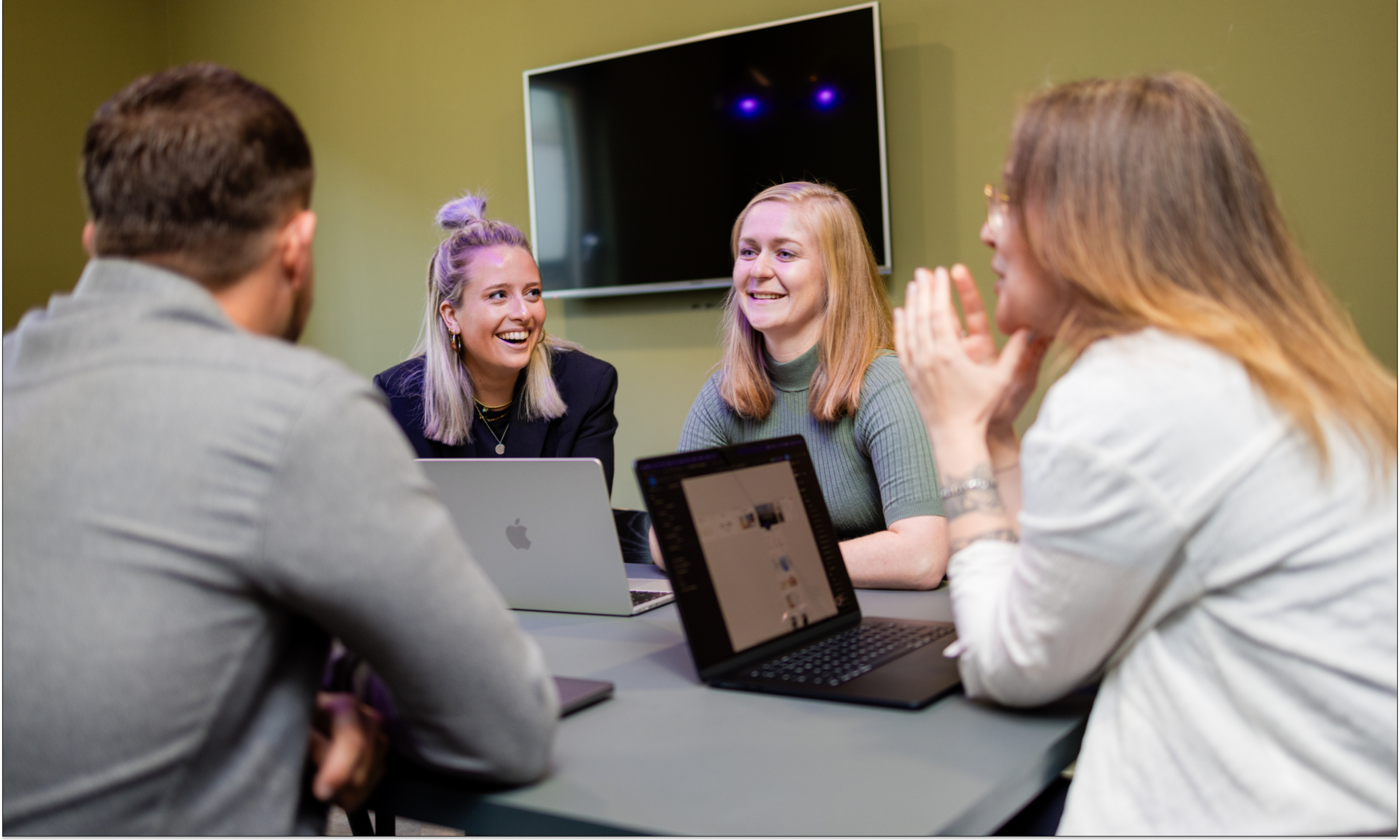 Floris, Ilse, Puck en Kayleigh zijn in overleg in een vergaderruimte