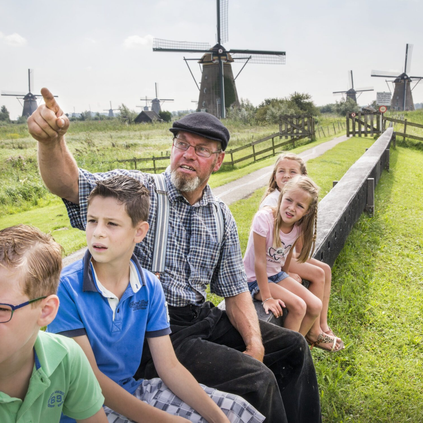 Een molenaar vertelt over molens tegen een groepje kinderen
